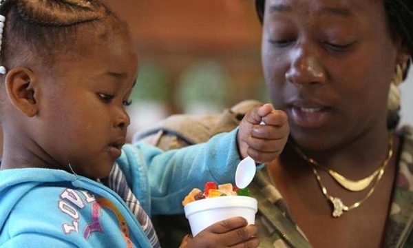 Photo mother and sharing a cup of ice cream